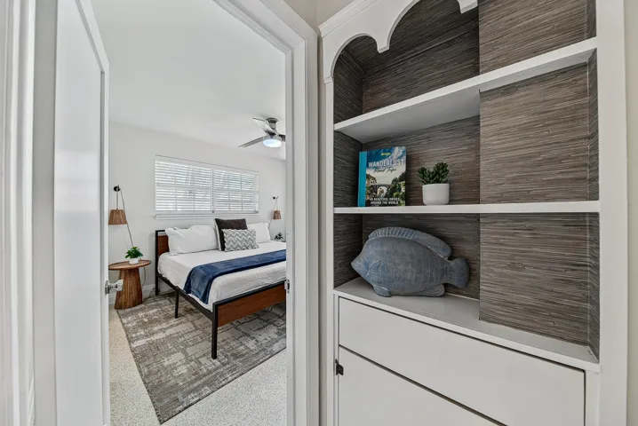 Built-in shelving with white cabinetry, and a ceiling fan