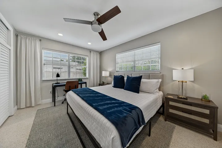 Ceiling fan with wooden blades, recessed lighting, double windows with blinds, and light-toned wall paint