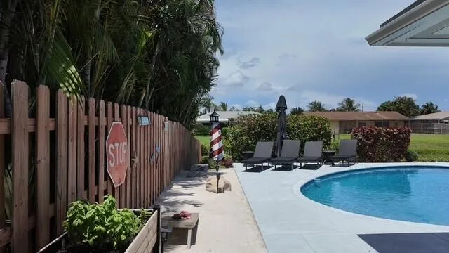 This resort-style pool area brings a touch of the beach home with its sandy retreat, tropical landscaping, and inviting lounger space. It creates a private coastal-inspired oasis right in your own backyard.