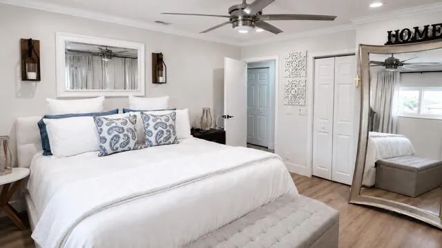 This spacious primary bedroom, with a walk in California closet offers a bright, serene retreat with Neutral finishes, warm wood flooring and natural light.