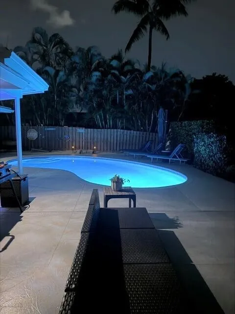 Relax and unwind beside the beautifully multicolored light, illuminating pool, creating a serene backyard after sunset. Comfortable outdoor seating set the perfect atmosphere for peaceful evenings and entertaining under the stars.
