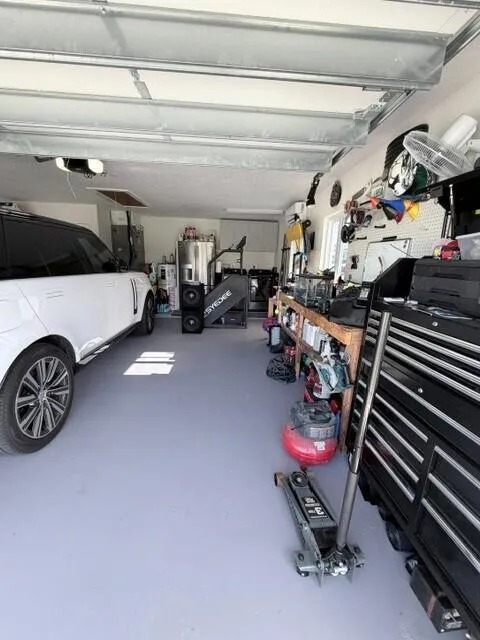 This Air conditioned garage features a dedicated workstation and ample room for tolls, storage, and everyday projects. A convenient laundry area with washer and dryer adding functi9onality while keeping household tasks organized and easily accessible.