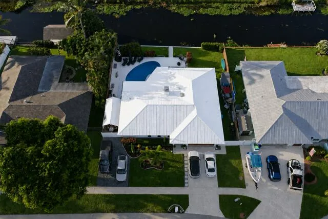 This impressive aerial view showcases the home's beautifully landscaped curb appeal, two driveways, and friendly neighbors.