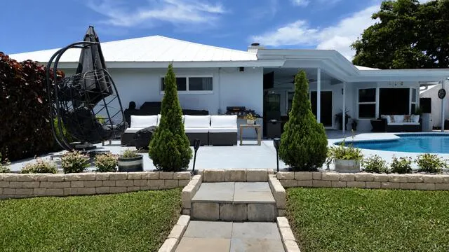Custom Stone steps and coordinating stone walls create a beautiful transition from the lush backyard to the pool and spacious outdoor living area.