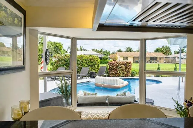This expansive kitchen bay window fills the space with natural light offering beautiful views of the pool, lush landscaping and canal.