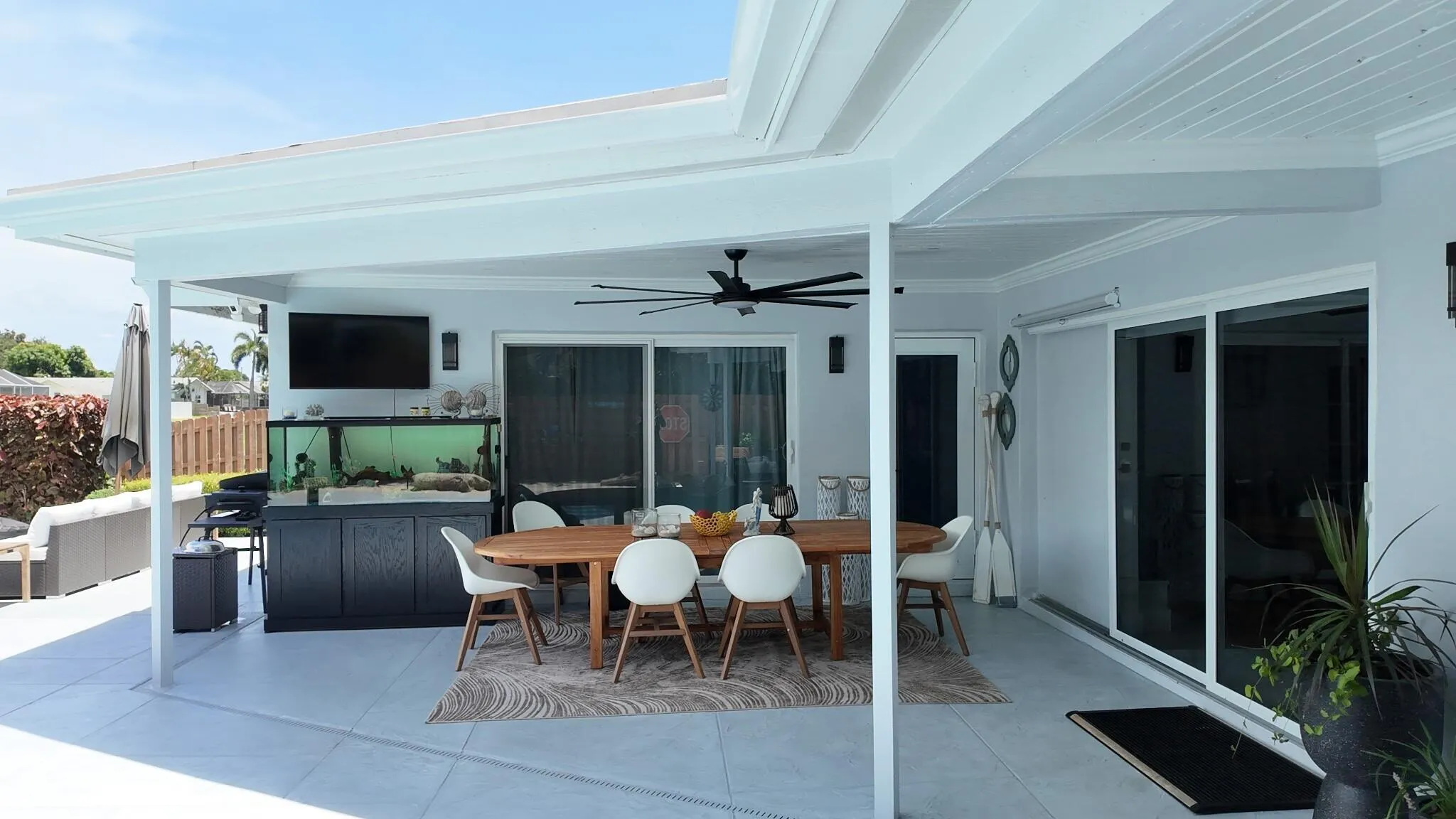 This spacious covered patio area offers the perfect setting for outdoor dining and entertaining while overlooking the peaceful waterfront canal.