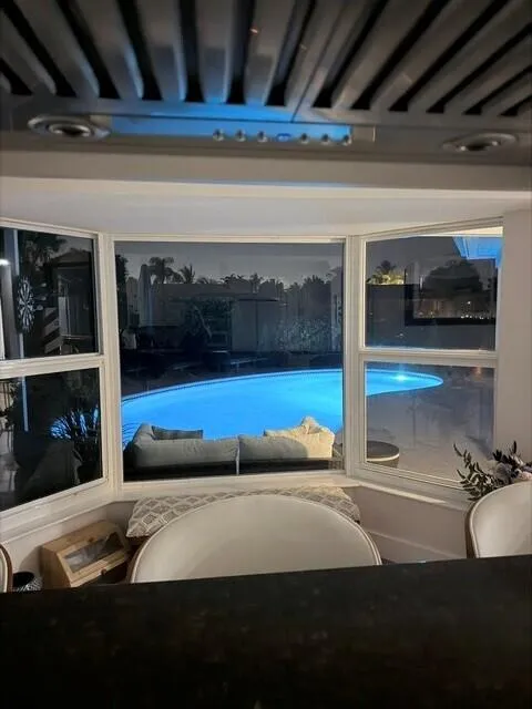 Kitchen Bay window creates a stunning nighttime view of the beautiful illuminated pool and outdoor living area.