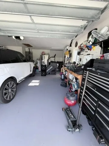 This Air conditioned garage features a dedicated workstation and ample room for tolls, storage, and everyday projects. A convenient laundry area with washer and dryer adding functi9onality while keeping household tasks organized and easily accessible.