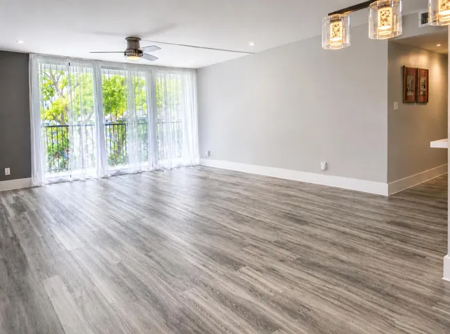 "Empty version" Huge living room featuring impact-resistant sliding glass doors leading to the balcony