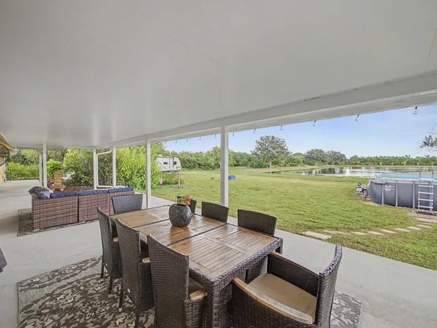 Covered Lanai with concrete flooring, overhead ceiling fan, outdoor wall lighting, and direct outdoor access