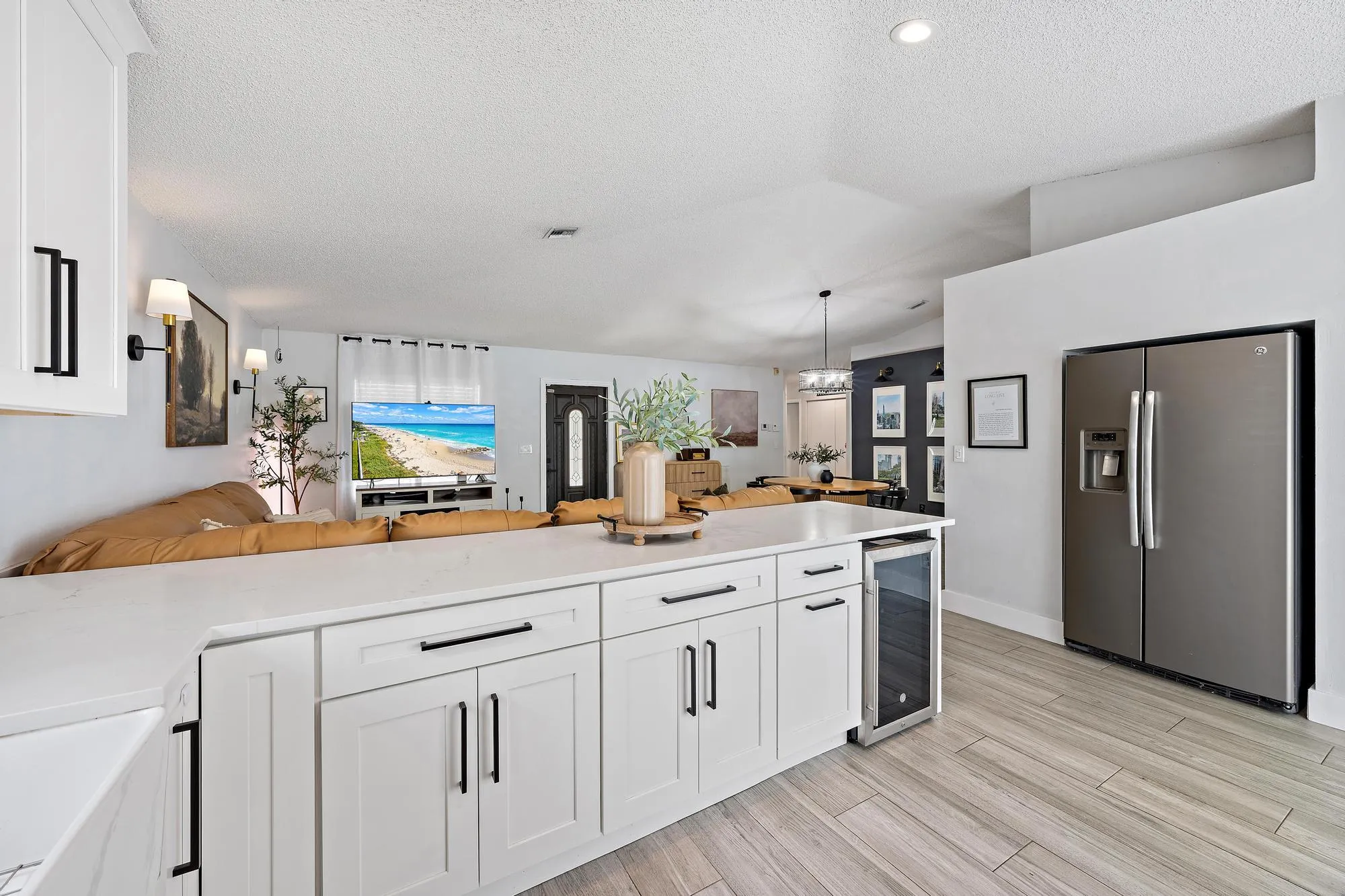 Kitchen island with white shaker-style cabinetry, a white countertop, and integrated beverage refrigerator