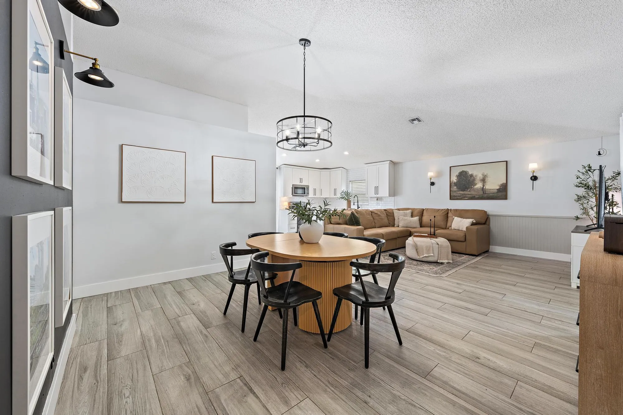Recessed lighting and a decorative chandelier illuminate the room