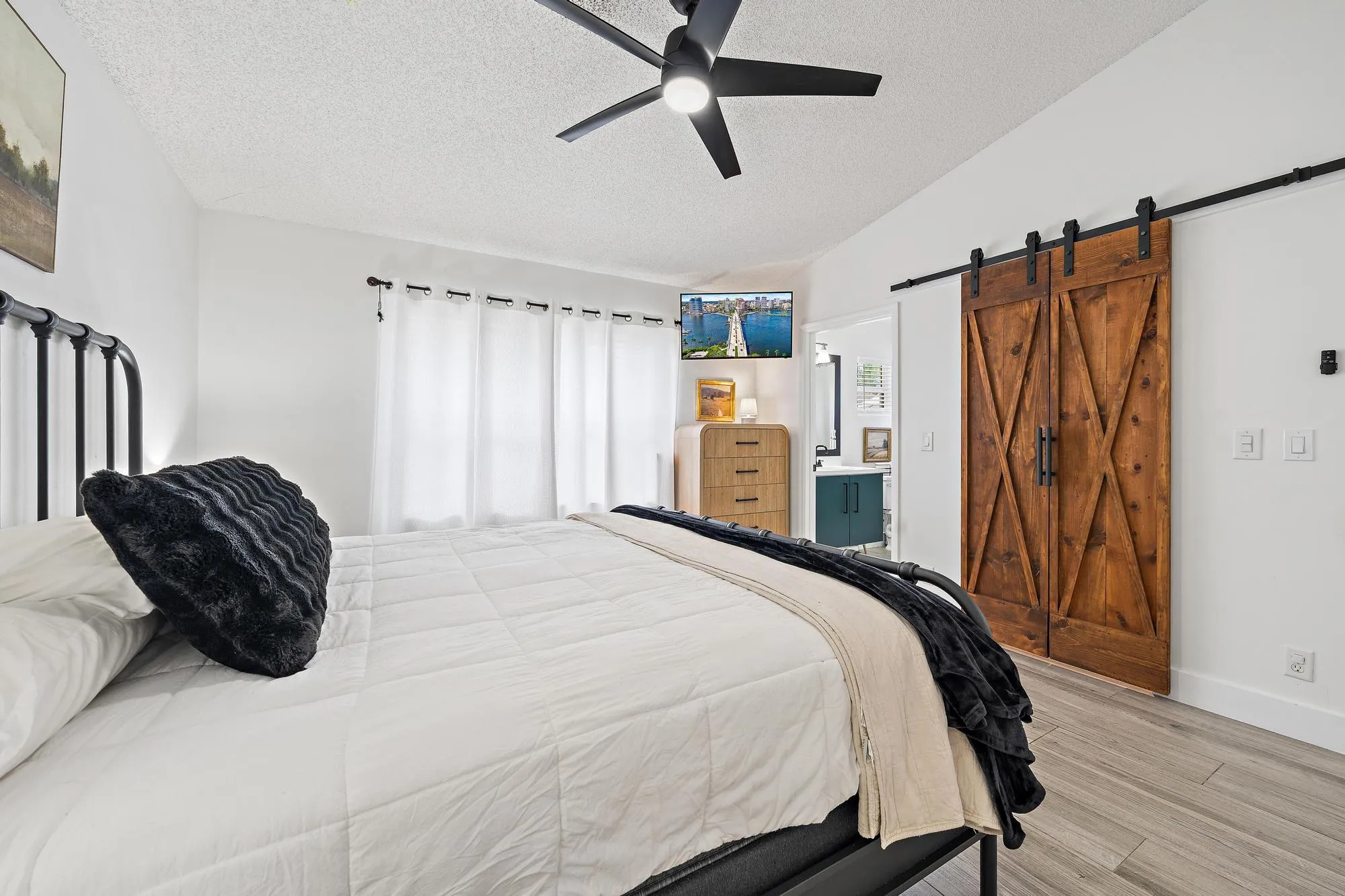 Wood-finish flooring, ceiling fan, and white walls