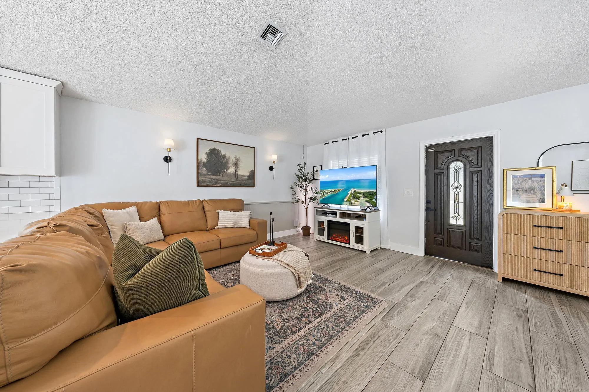Wood-finish flooring throughout, white walls, and built-in wall sconces