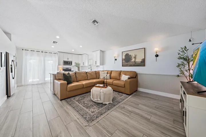 Light wood-finish flooring, white paneled lower wall, white upper walls, recessed lighting, and built-in white cabinetry