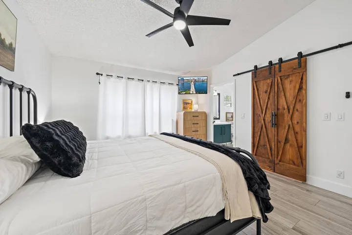Wood-finish flooring, ceiling fan, and white walls