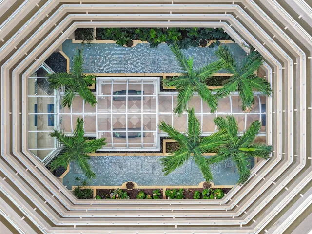 Birds-eye view of the stunning open-air atrium, bringing natural light and tropical beauty to the heart of the building.