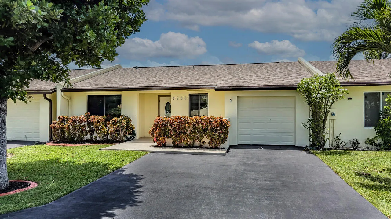 Light-colored stucco exterior with a biege shingle roof