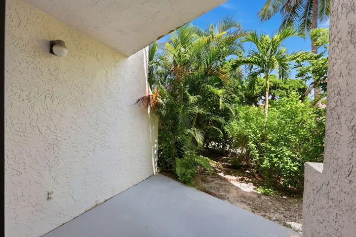 Outdoor patio featuring textured stucco walls and tropical landscaping