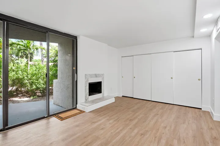 Wood-finish flooring, sliding glass patio door, marble-surround fireplace,