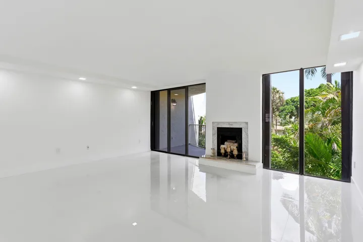 Spacious interior featuring white tile flooring, recessed lighting, and a white marble fireplace