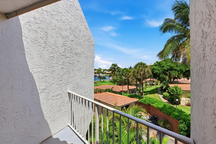 Balcony with a metal railing, stucco exterior, and a water feature