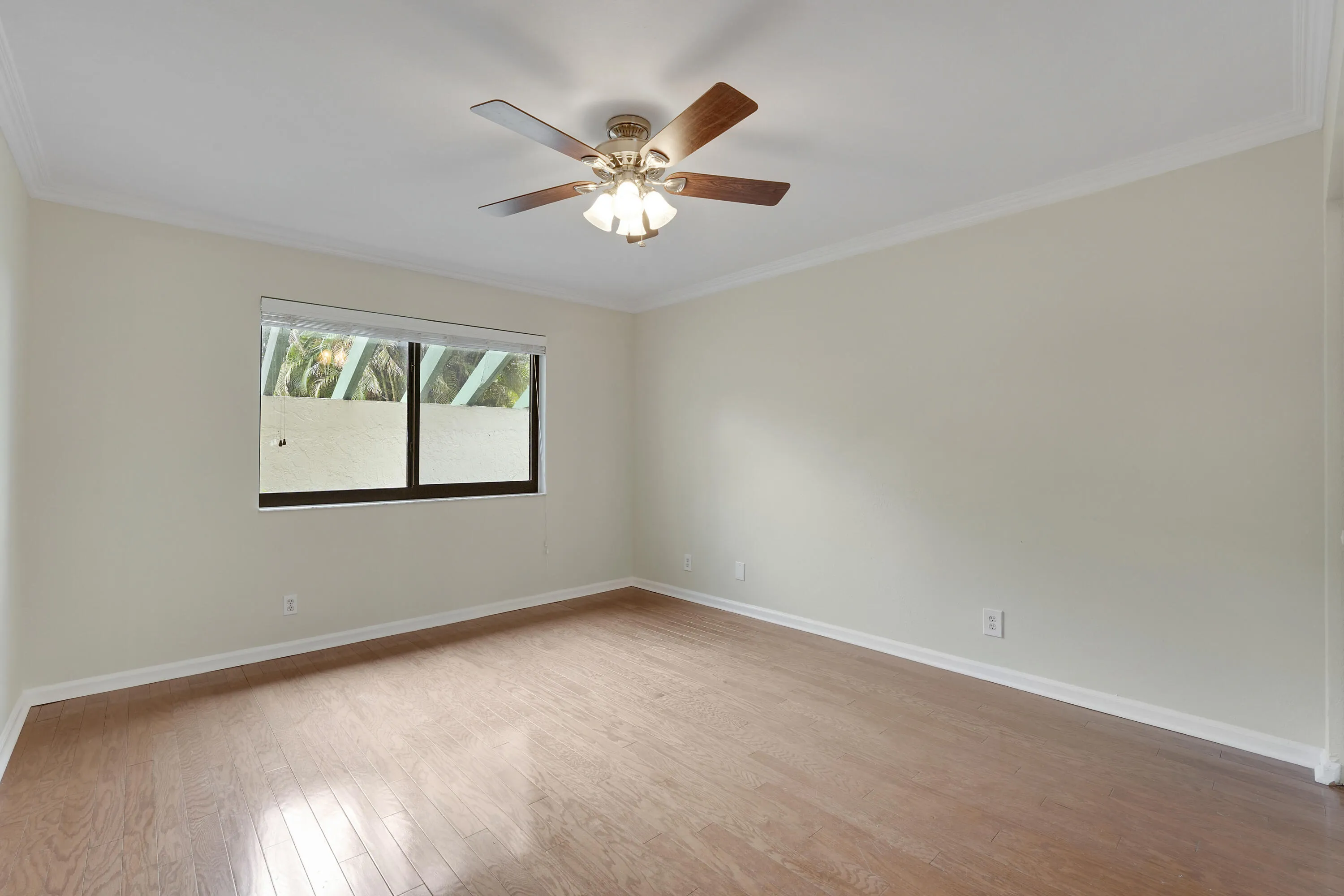 2nd bedroom with wood flooring and crown molding