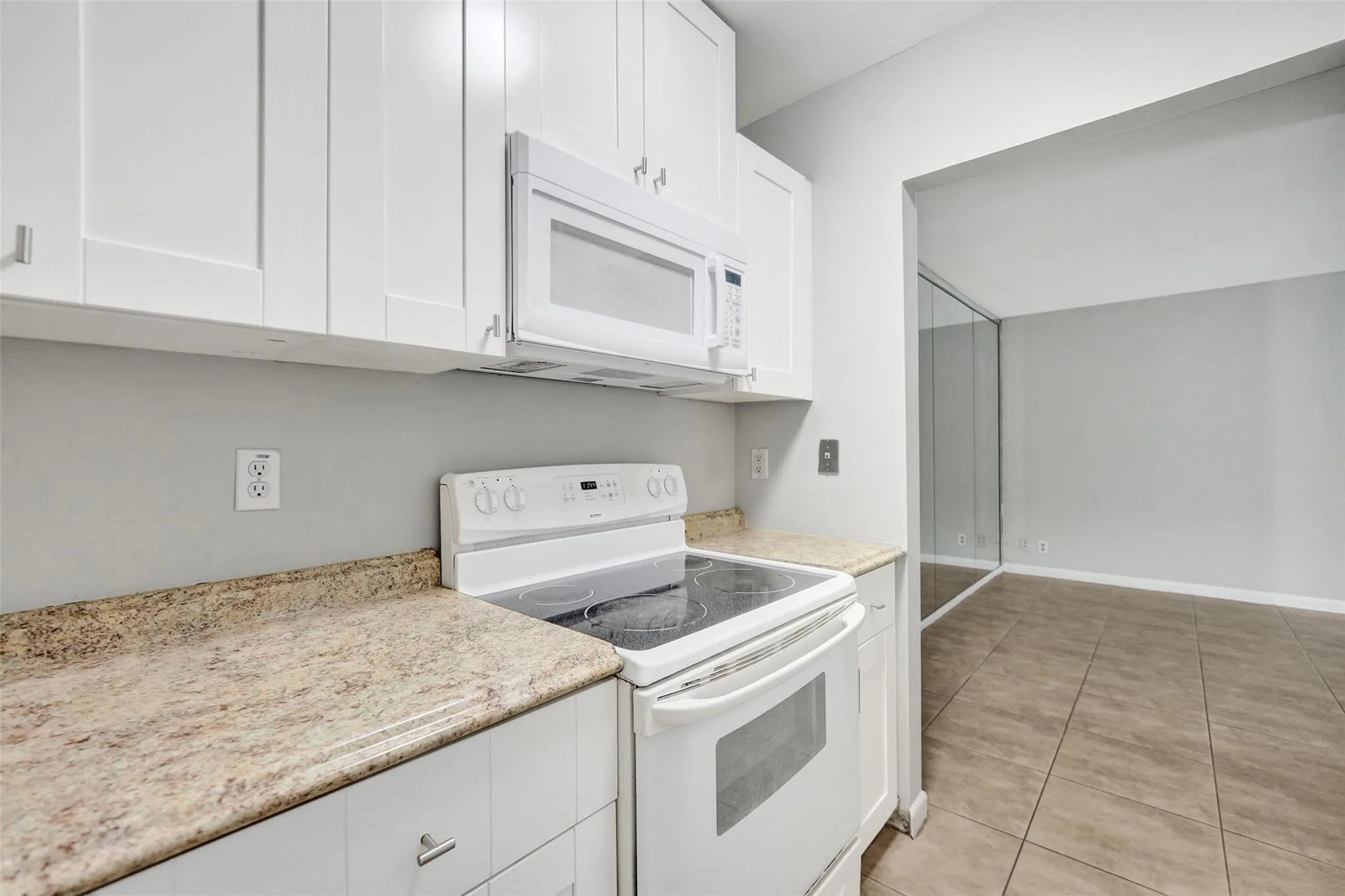 White cabinetry and a built-in microwave oven