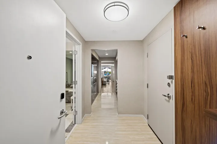 Hallway featuring light-colored flooring, neutral wall finishes, and a flush-mount ceiling light