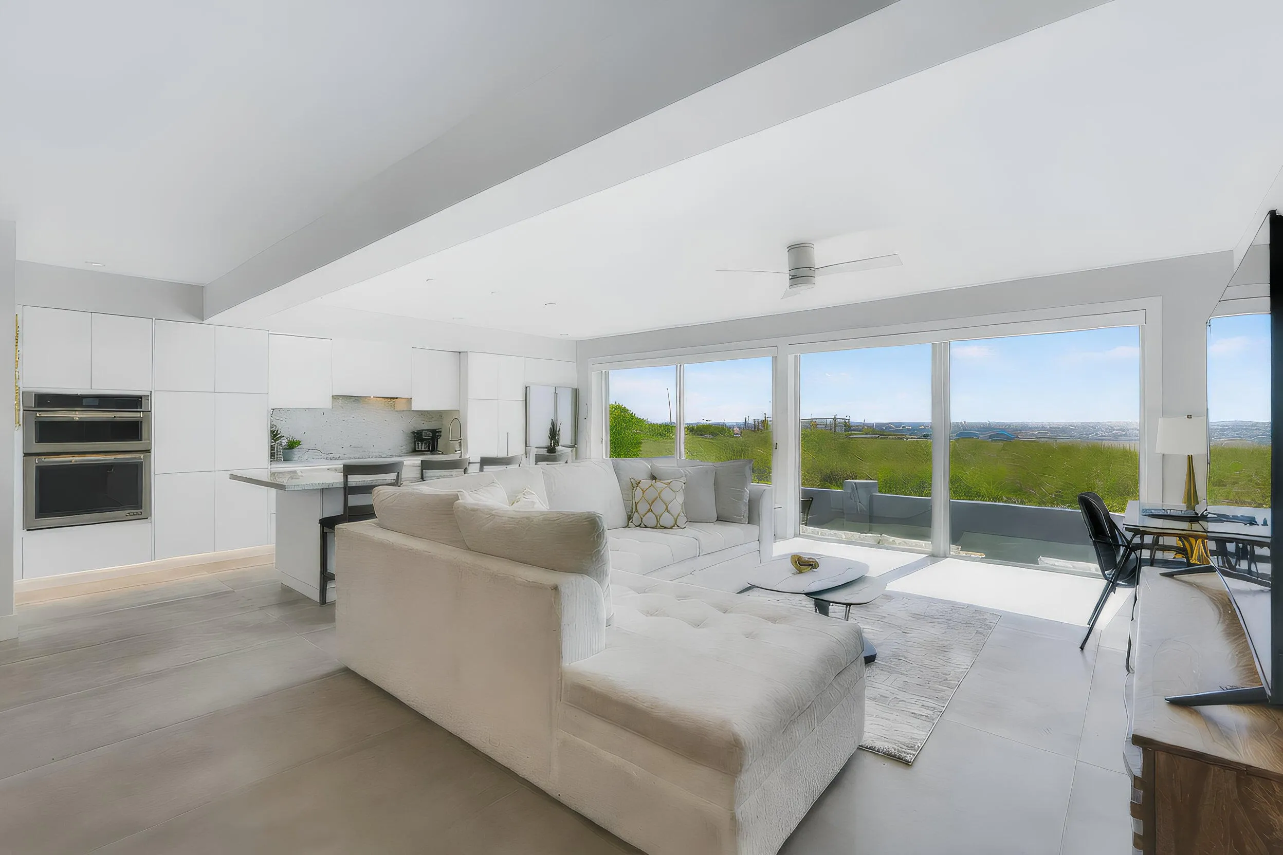 Integrated kitchen with white cabinetry and built-in double ovens