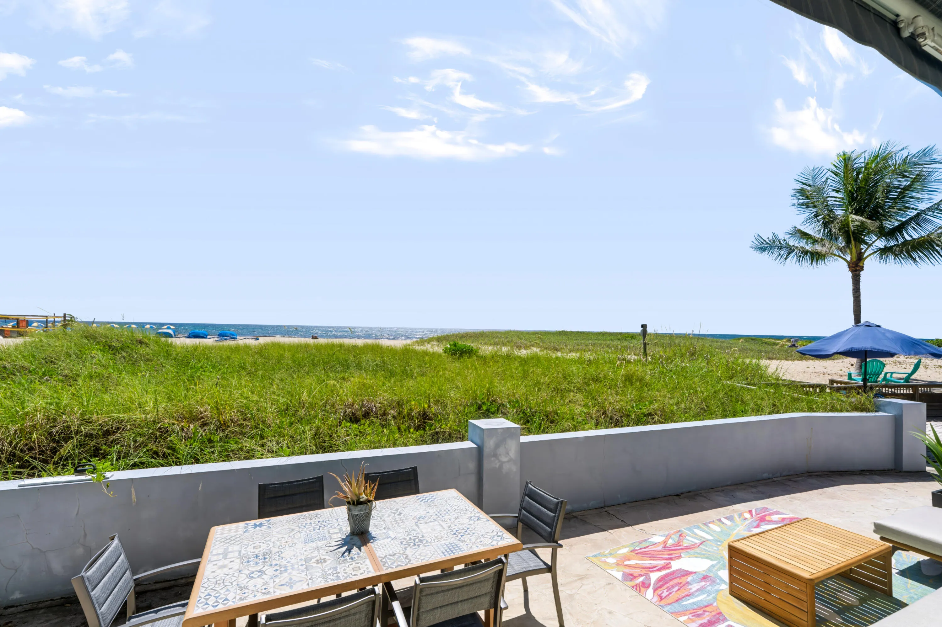Beachfront property with direct access to a sandy shoreline, ocean, and natural dune landscaping