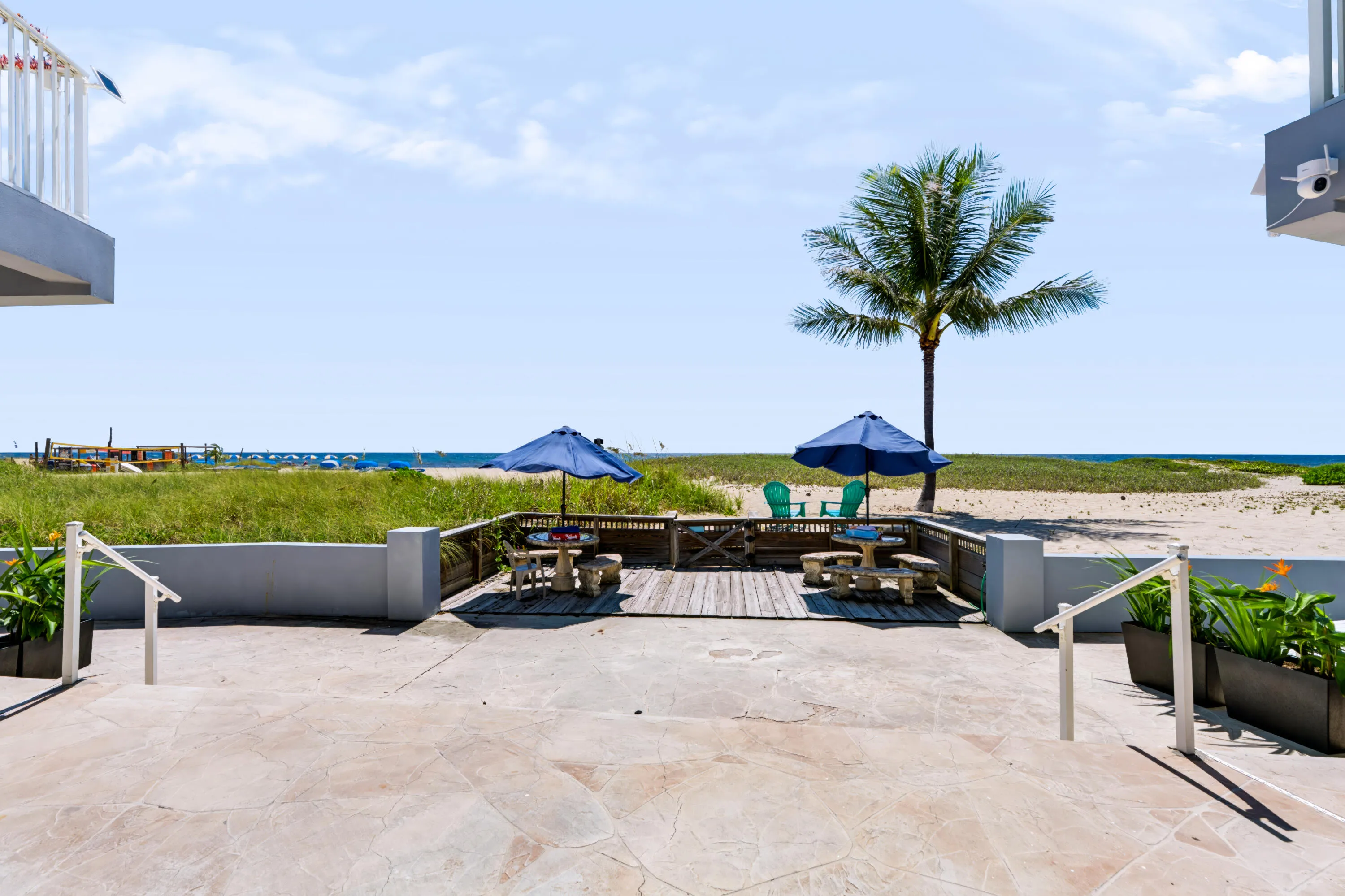 Stone paver patio with planter boxes, leading to a wood-finish deck