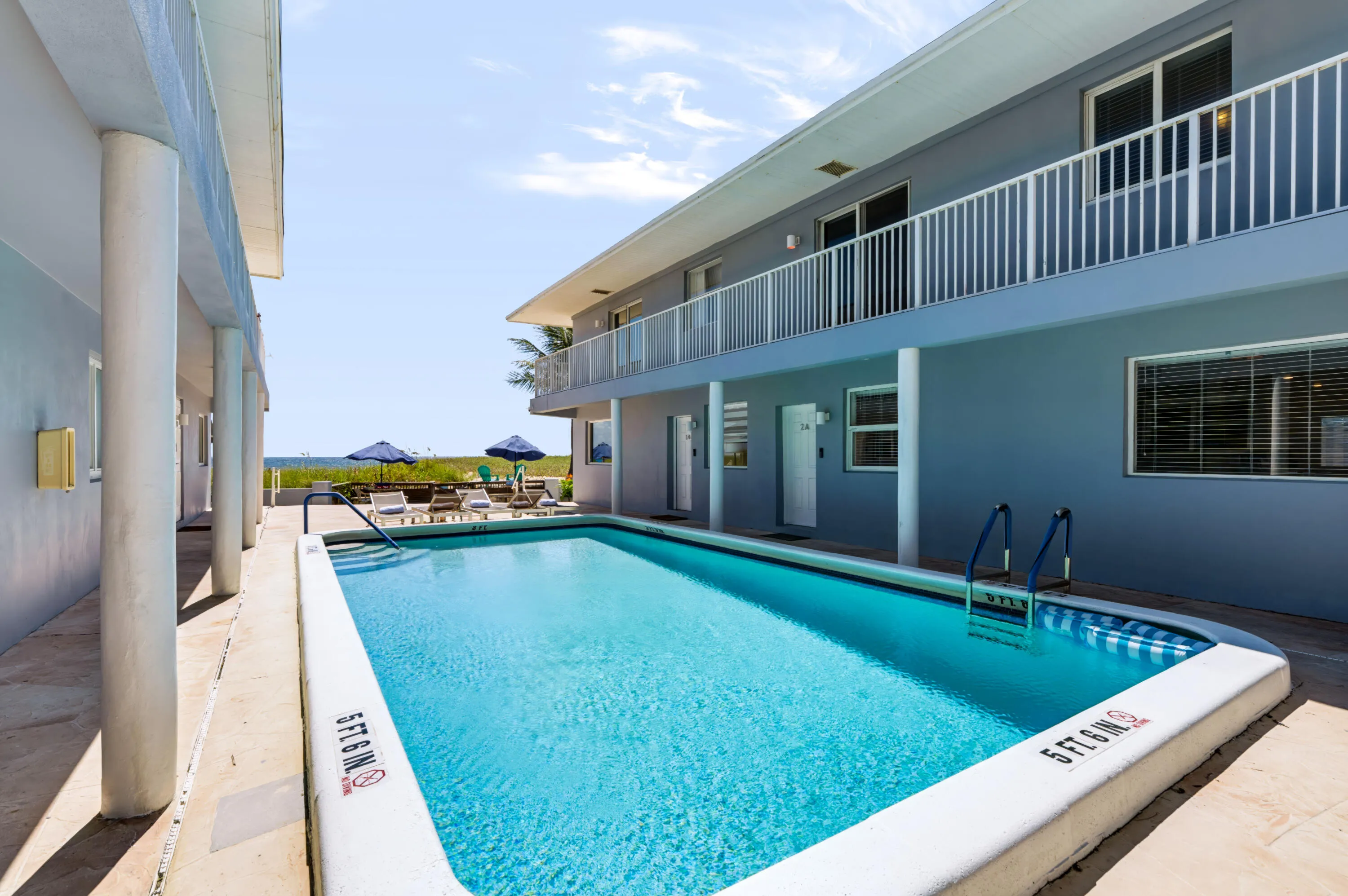 Exterior swimming pool with integrated steps, surrounded by a concrete deck