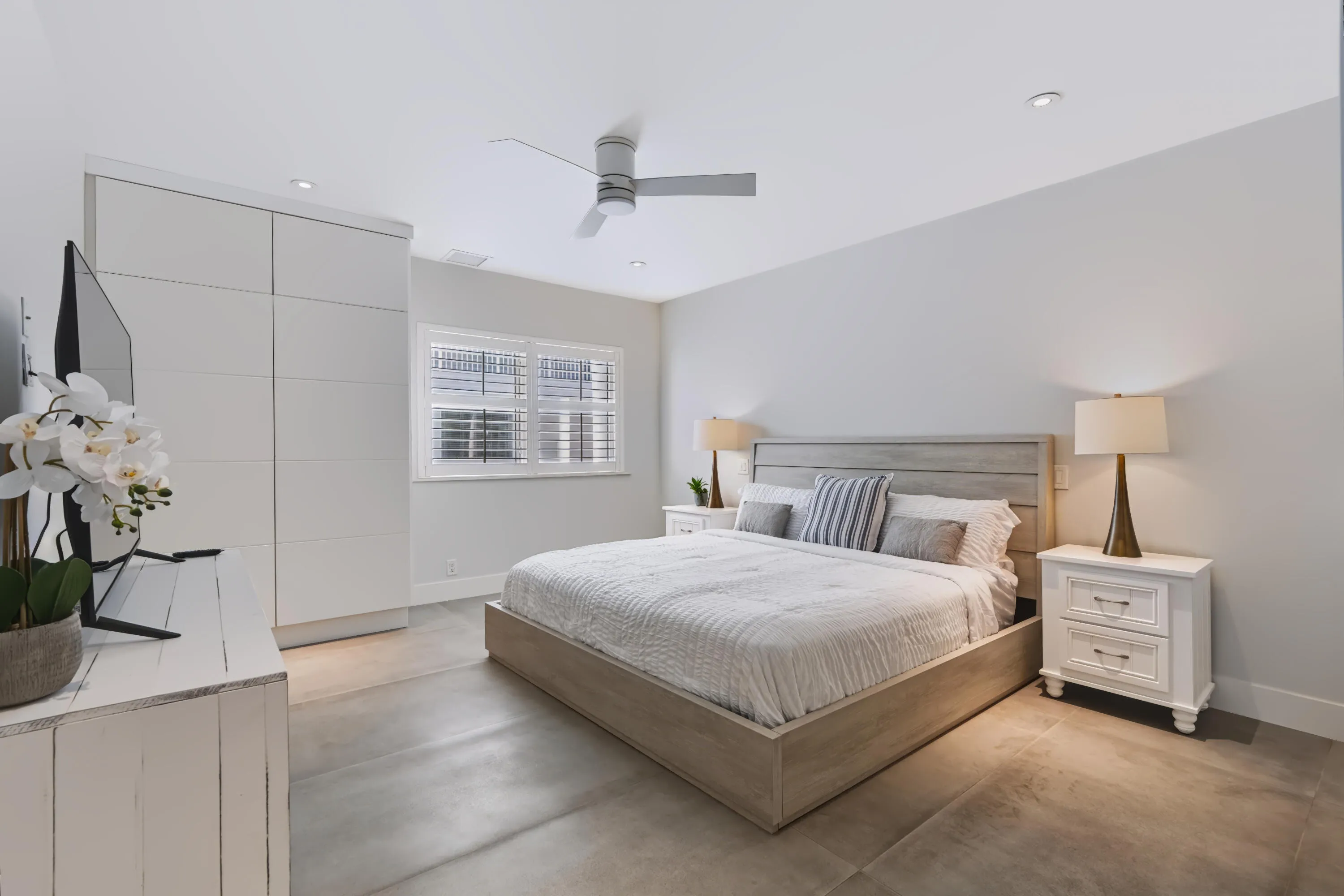 Built-in cabinetry with flush panel doors, recessed ceiling lighting, a ceiling fan, and large-format tile flooring
