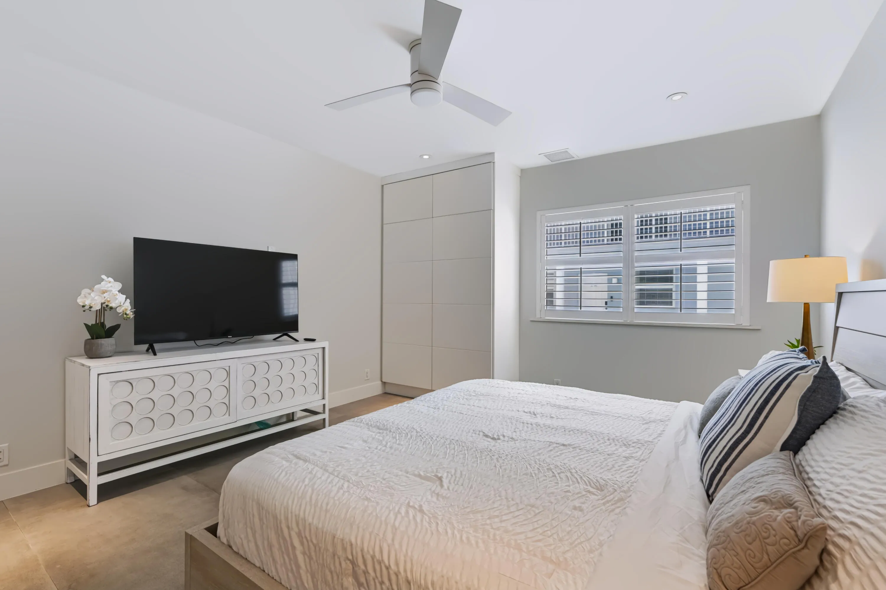 Recessed lighting throughout, ceiling fan with light fixture, built-in cabinetry, and window with plantation shutters