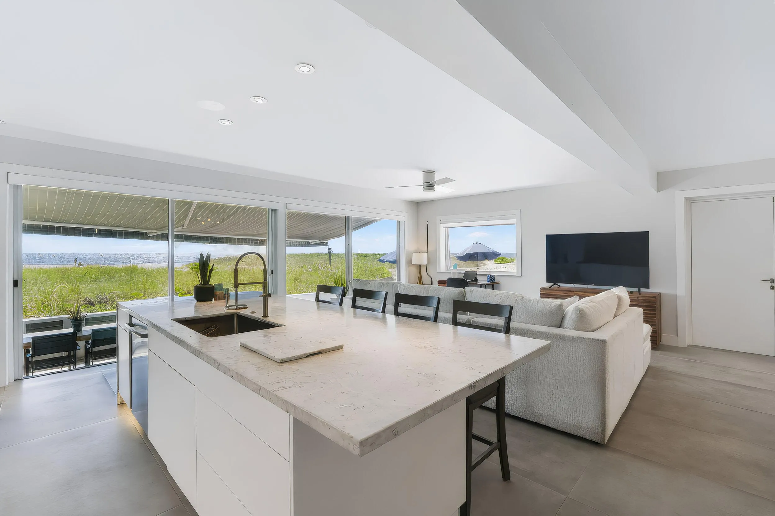 Kitchen island featuring an undermount sink, a gooseneck faucet, and integrated seating