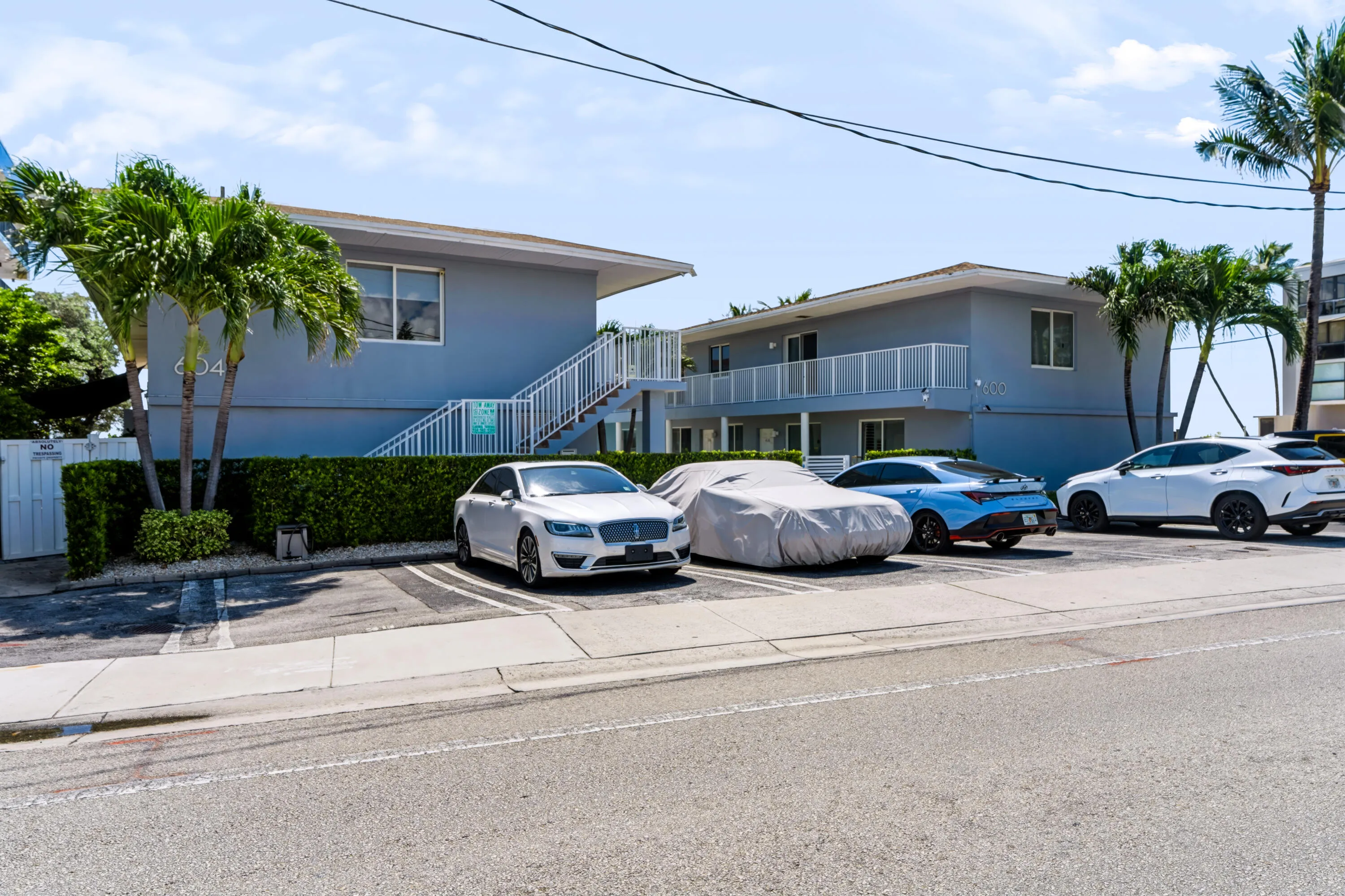 Two-story building featuring a light blue facade and white railings