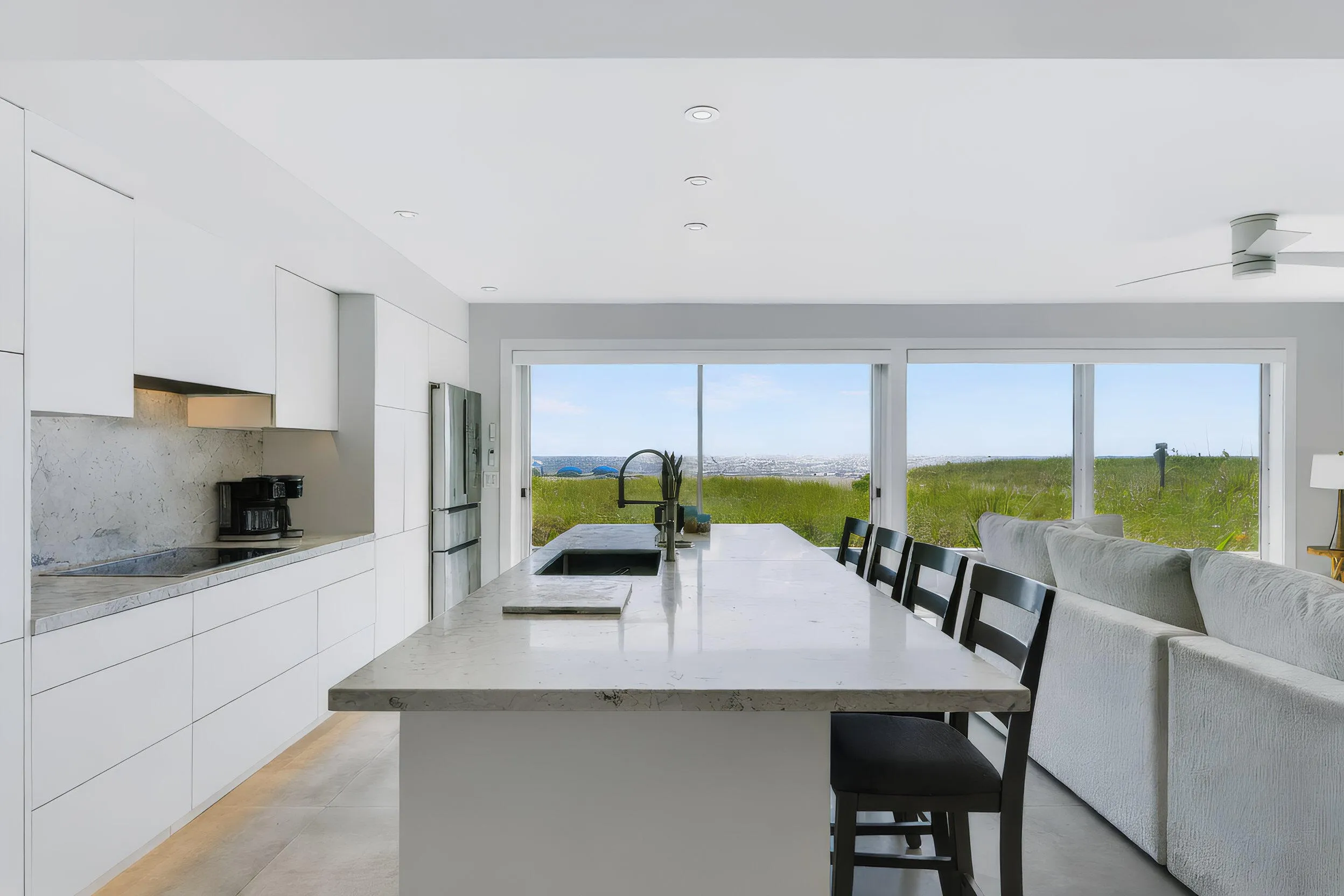 Contemporary kitchen featuring an integrated cooktop, stainless steel refrigerator, and recessed lighting