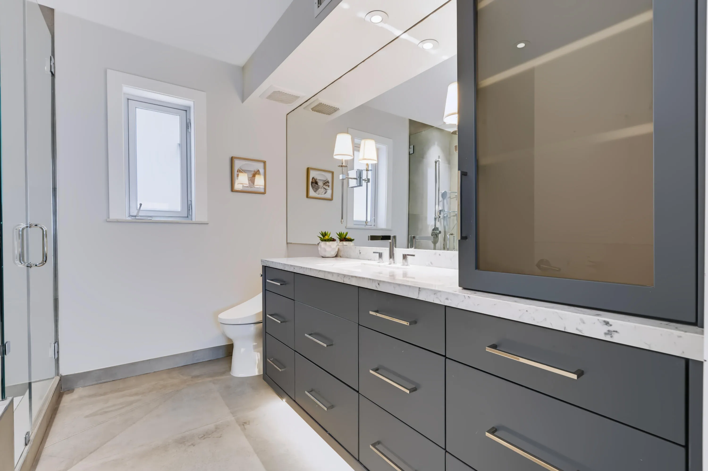 Vanity with extensive drawer storage, integrated countertop sink, and full-wall mirror