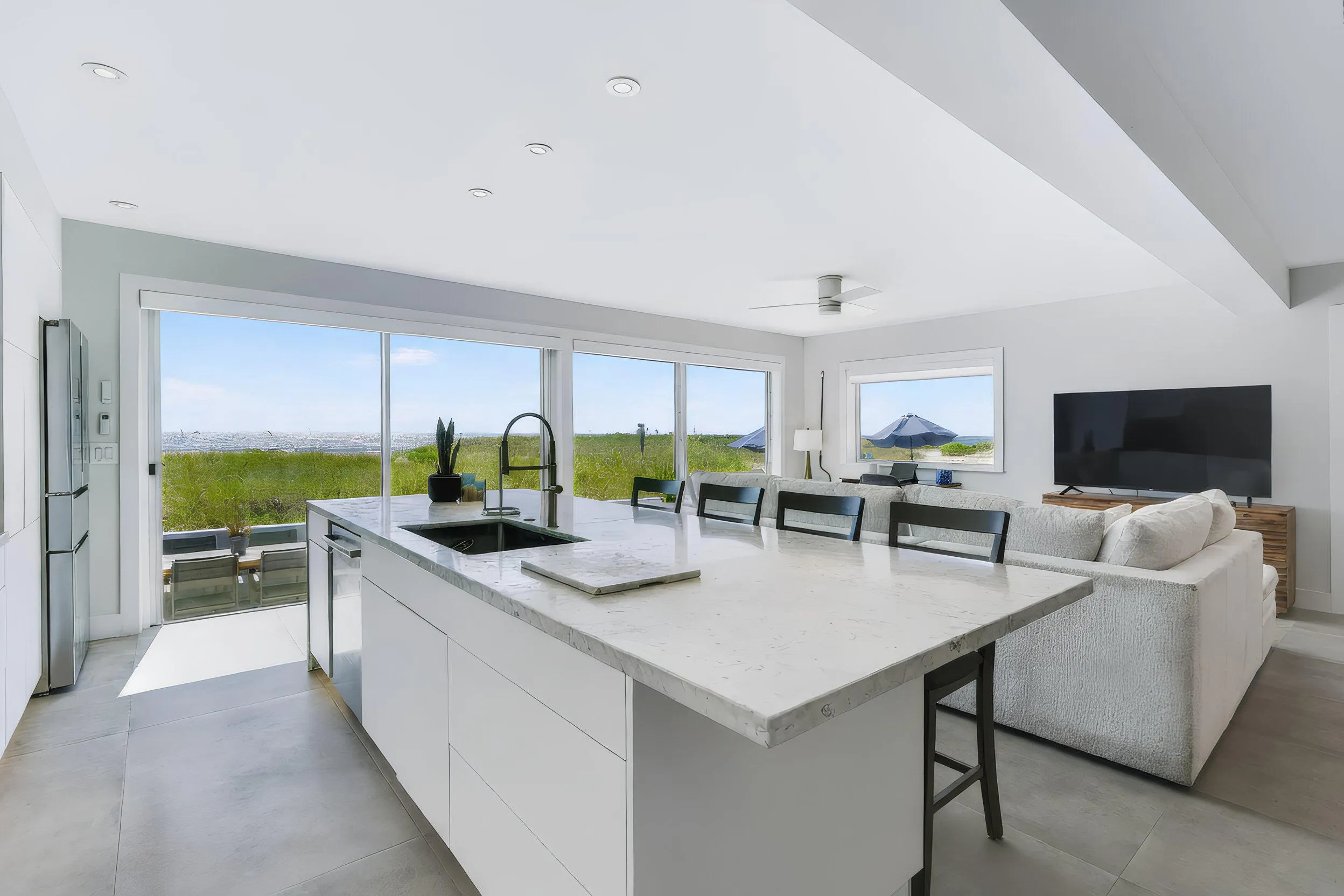 Open-concept living area with a kitchen island featuring a sink and seating