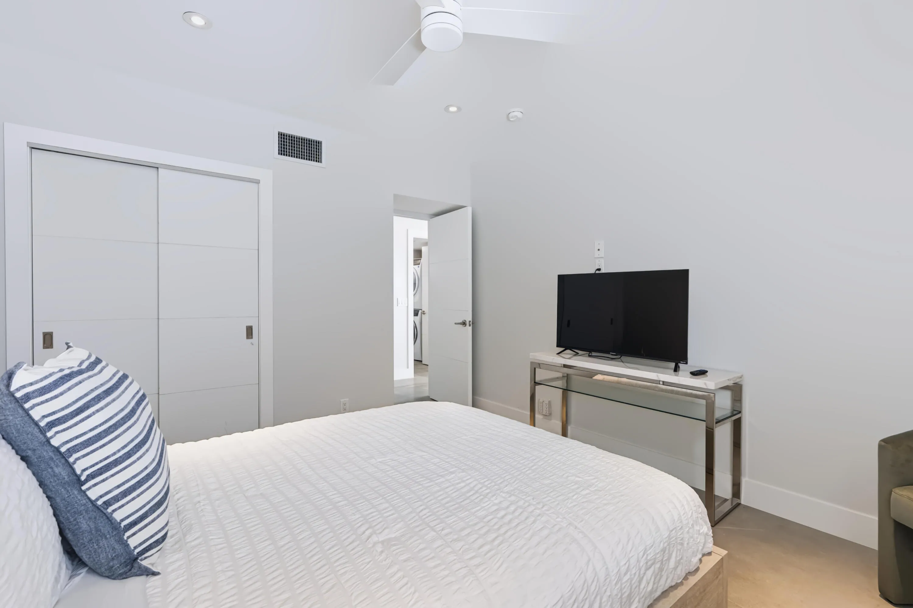 Recessed lighting, ceiling fan, white paneled sliding closet doors, and wood-finish flooring