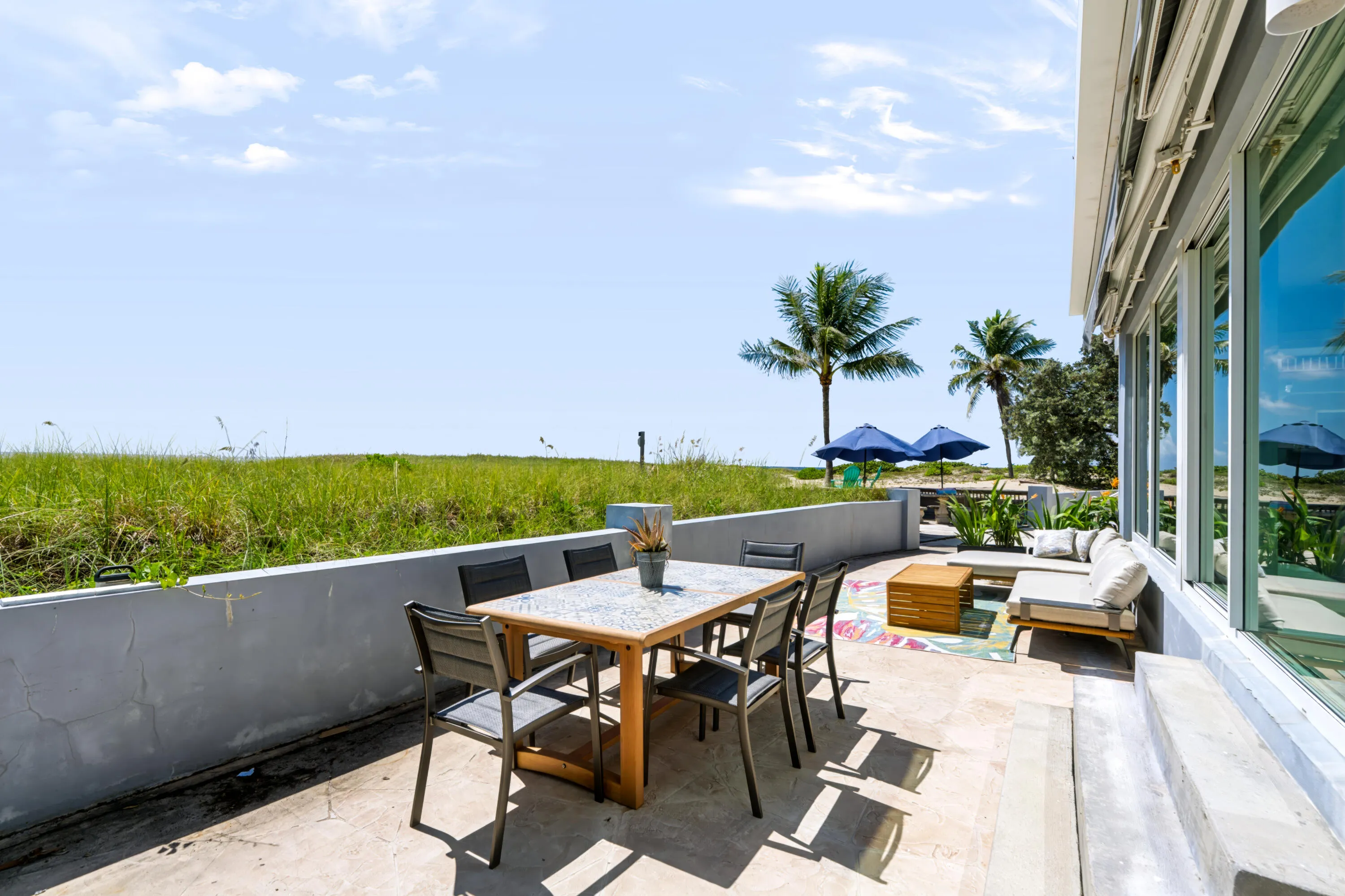 Outdoor patio with concrete flooring, stucco perimeter wall, and floor-to-ceiling windows