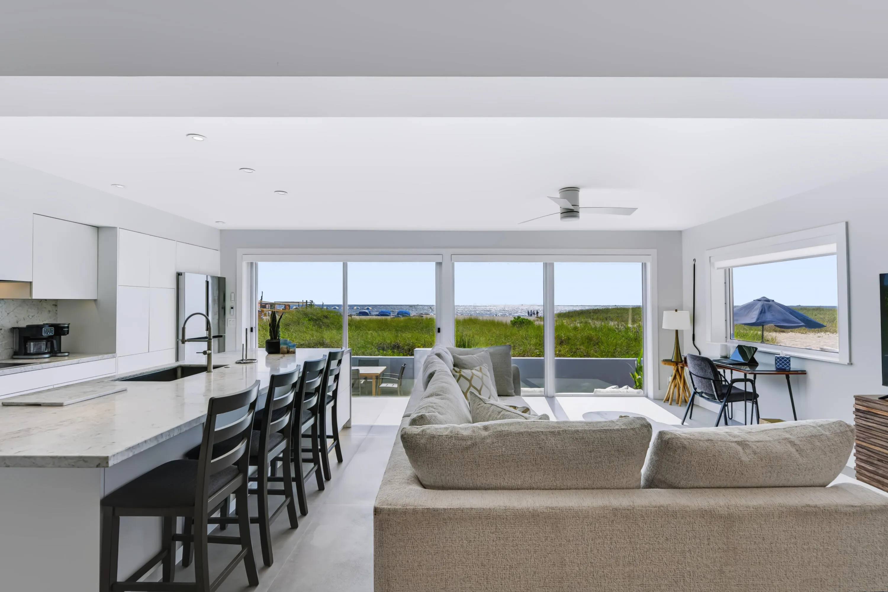 Open-concept living space featuring a kitchen island with seating, integrated sink, and modern cabinetry