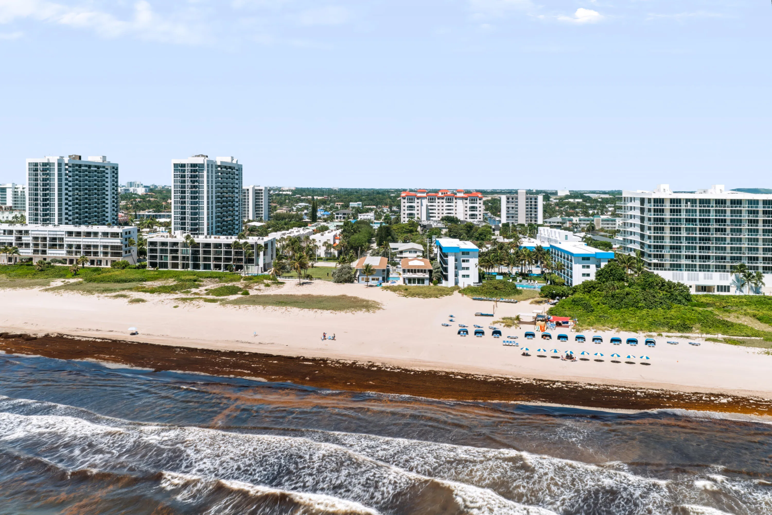 Coastal location featuring beachfront access, a wide sandy beach, and proximity to multi-story residential buildings