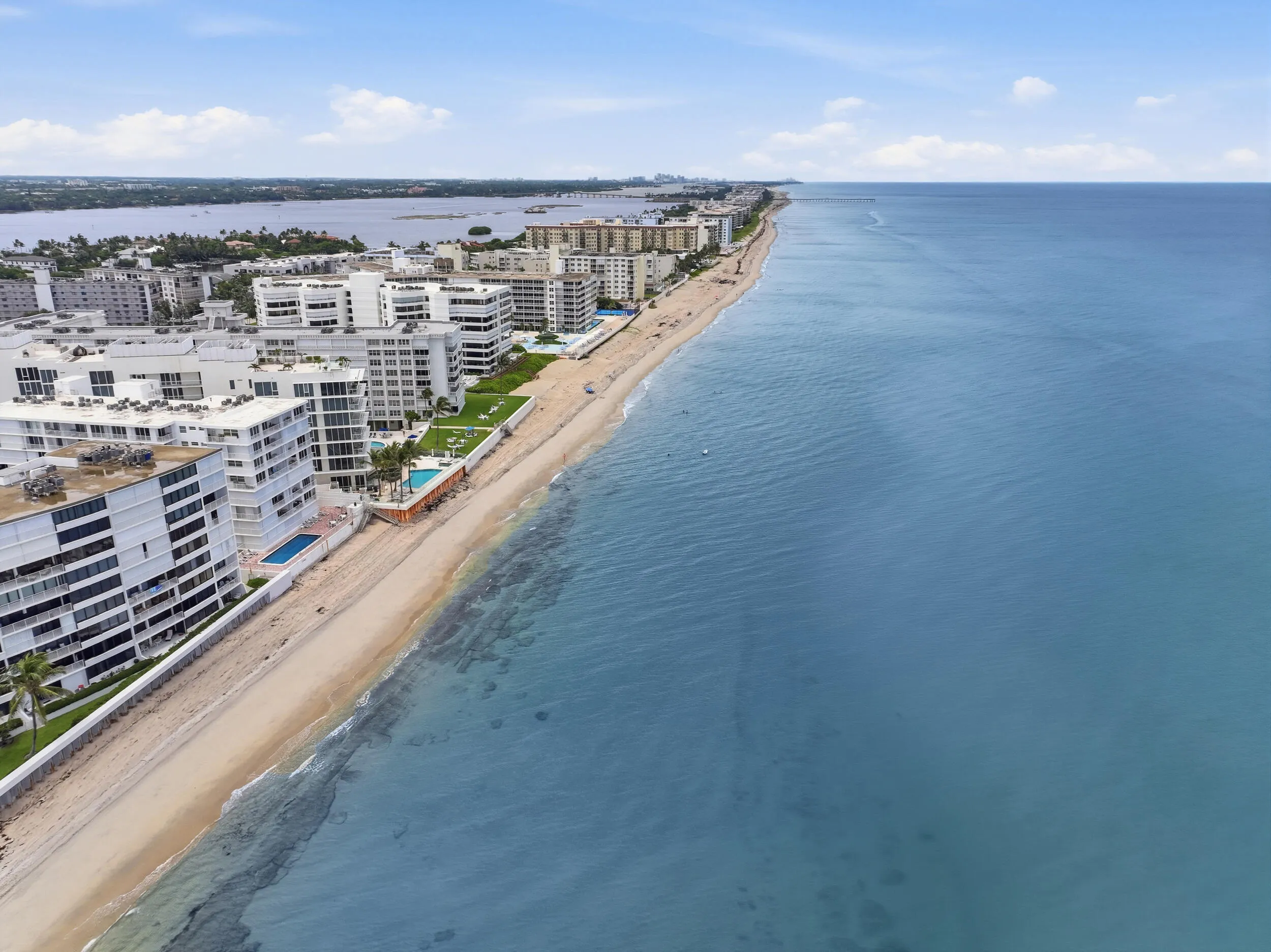 Coastal condominium buildings fronting a sandy beach and the ocean