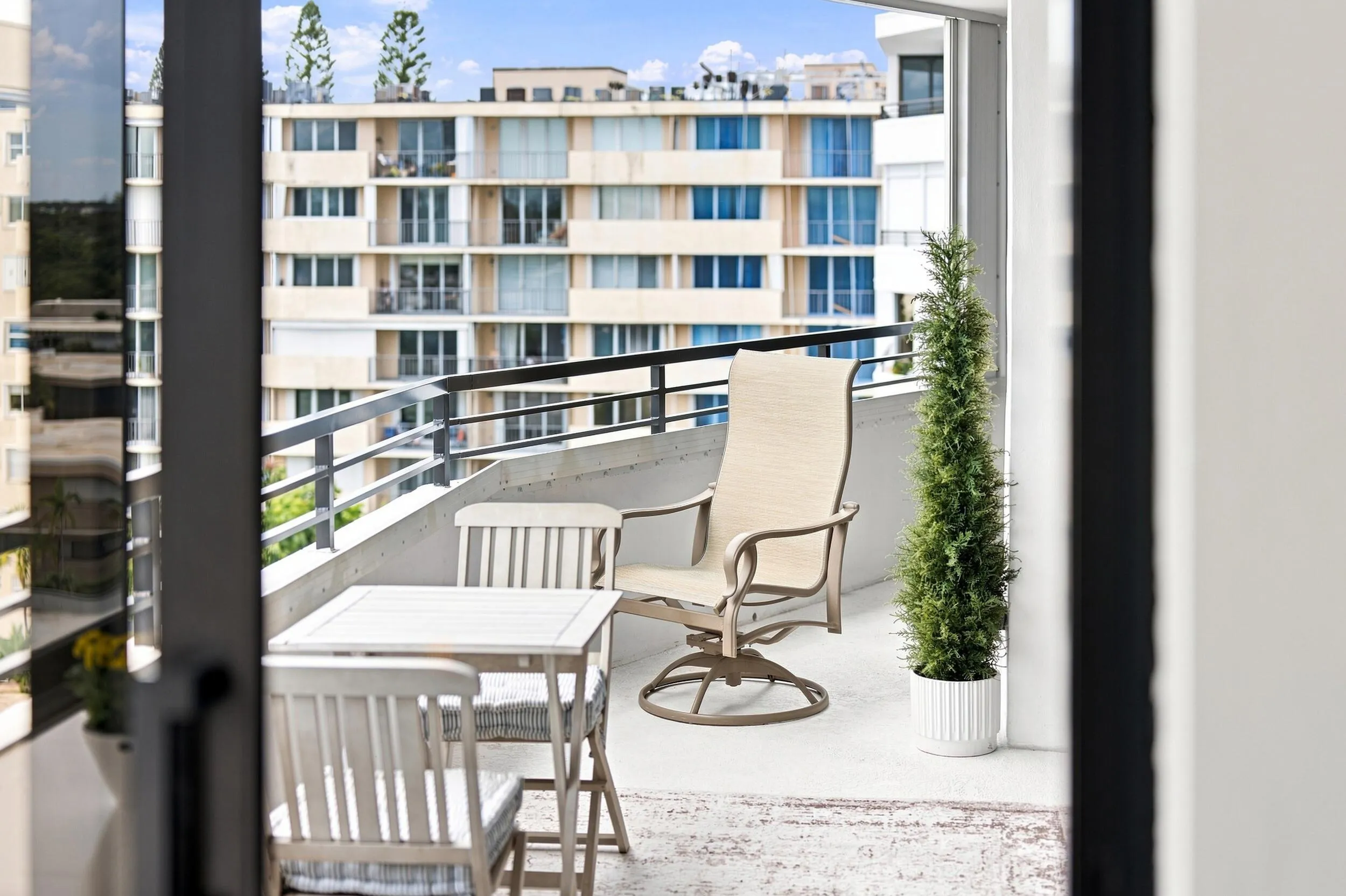 Private outdoor balcony featuring a concrete floor and a metal railing