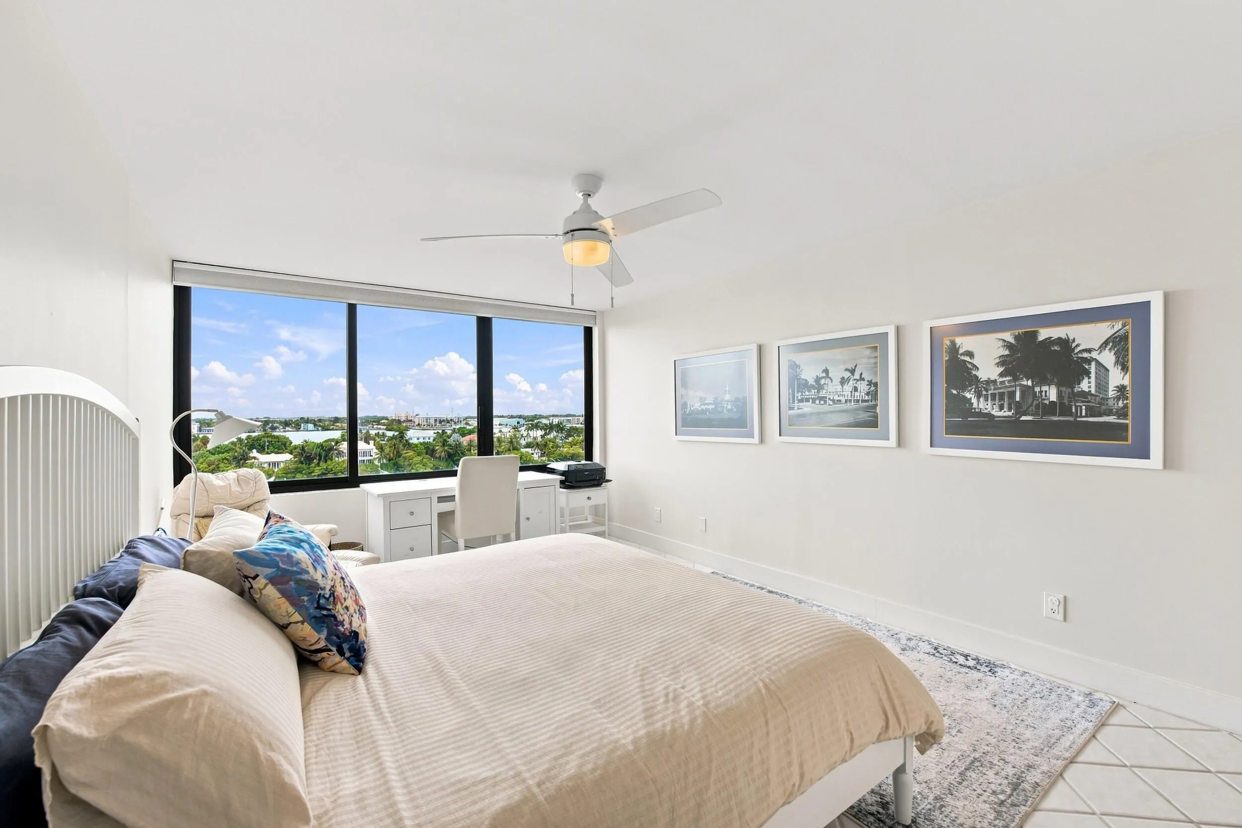 Spacious room featuring floor-to-ceiling windows, a ceiling fan with integrated lighting, and tile flooring