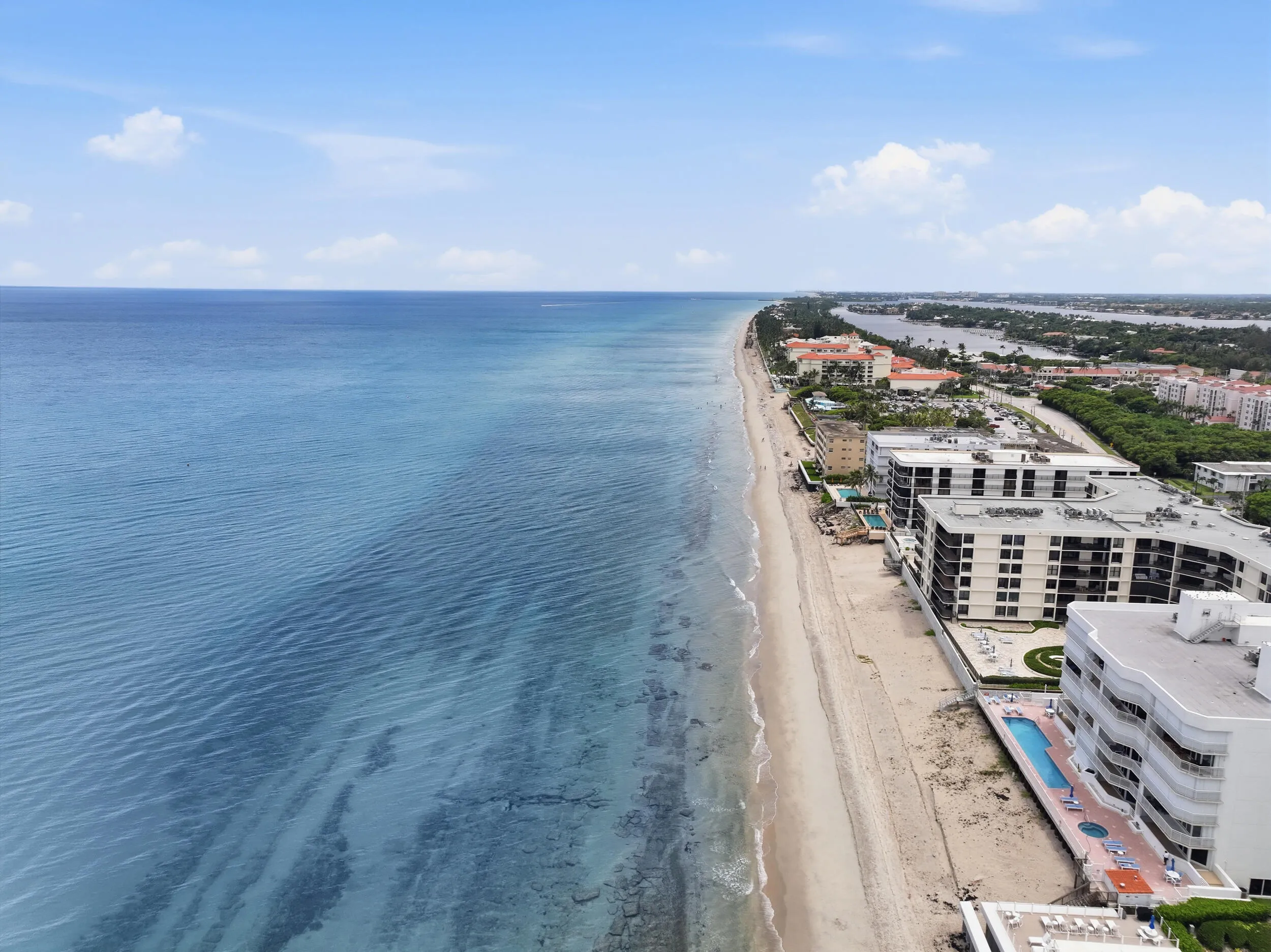Panoramic coastal scene featuring expansive ocean waters and an extensive sandy beach