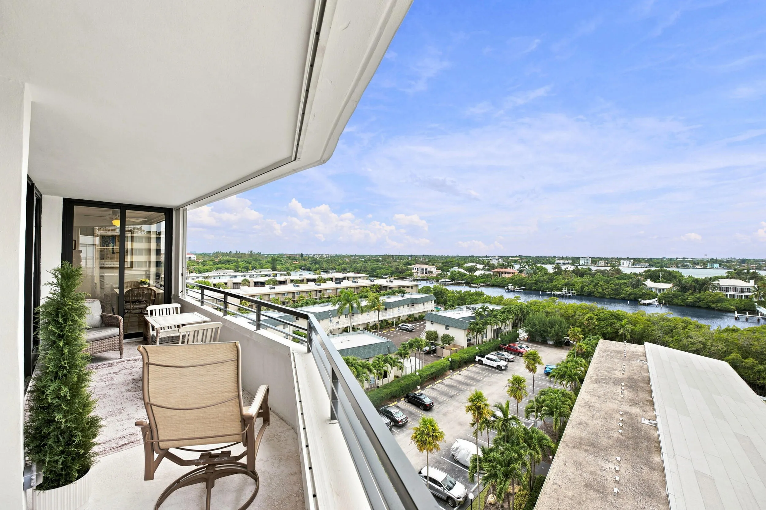 Spacious balcony featuring a curved architectural design, concrete flooring, and a black metal railing