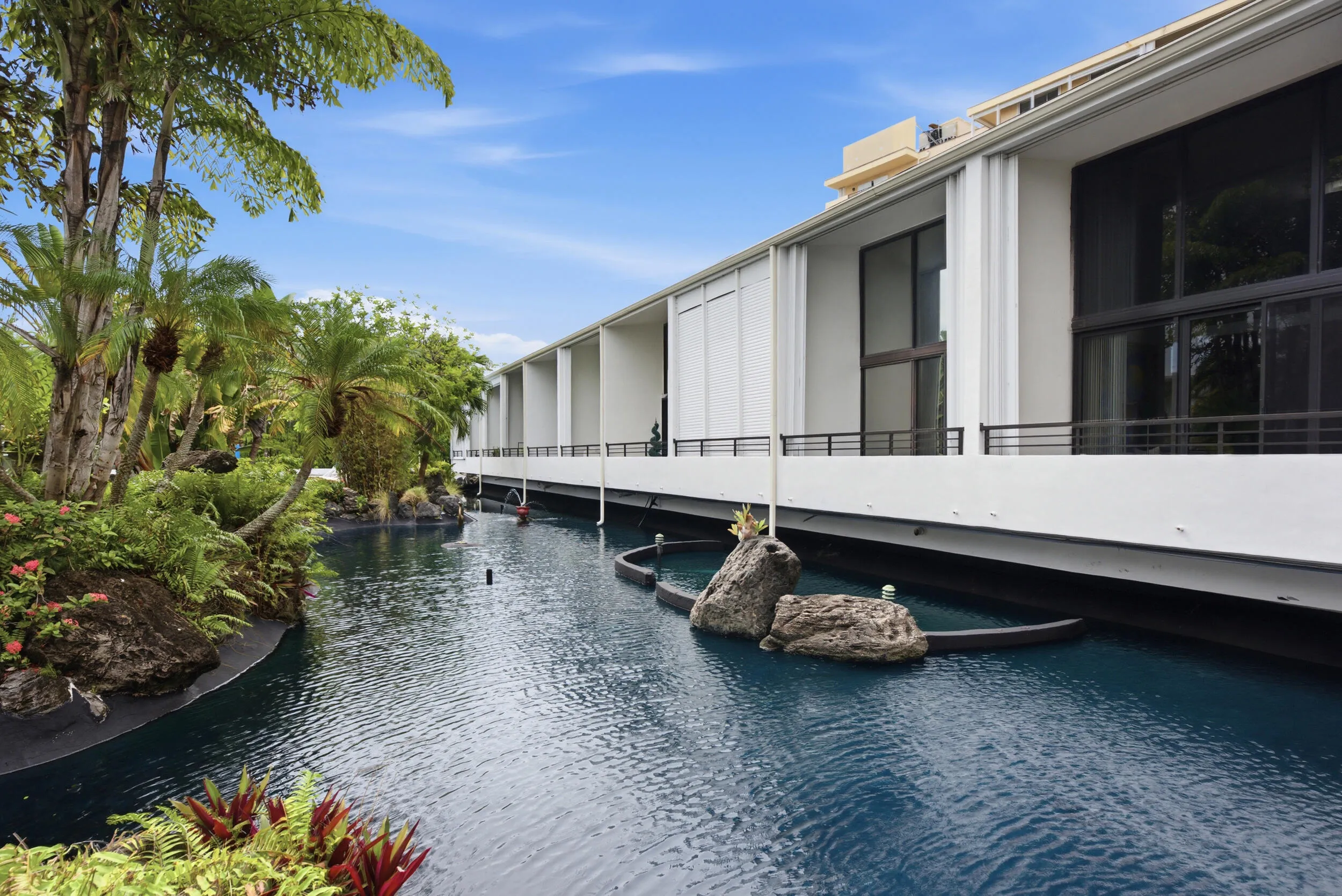 Contemporary building facade with large glass panels and sleek white siding